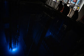 Operators peer into the reactor pool where Texas A&M University’s Training, Research, Isotopes, General Atomics (TRIGA) nuclear research reactor emits a blue glow on March 11, 2024 in College Station. Credit: Eli Hartman/The Texas Tribune