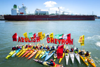 Activists with the Richmond-based Rich City Rays gather in front of a tanker carrying liquified natural gas in San Francisco Bay. Credit: Brooke Anderson