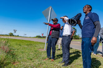 Transportation Secretary Pete Buttigieg stands with Dr. Robert Bullard (left) and Pastor Timothy Williams (right) during a tour of the Shiloh community in rural south Alabama. Credit: Lee Hedgepeth/Inside Climate News