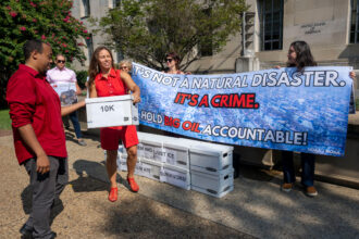 Activists from Public Citizen and the Chesapeake Climate Action Network deliver a letter with more than 10 thousand signatures from climate survivors and their allies to the Department of Justice on Thursday in Washington. Credit: Kevin Wolf/AP Content Services for Chesapeake Climate Action Network and Public Citizen