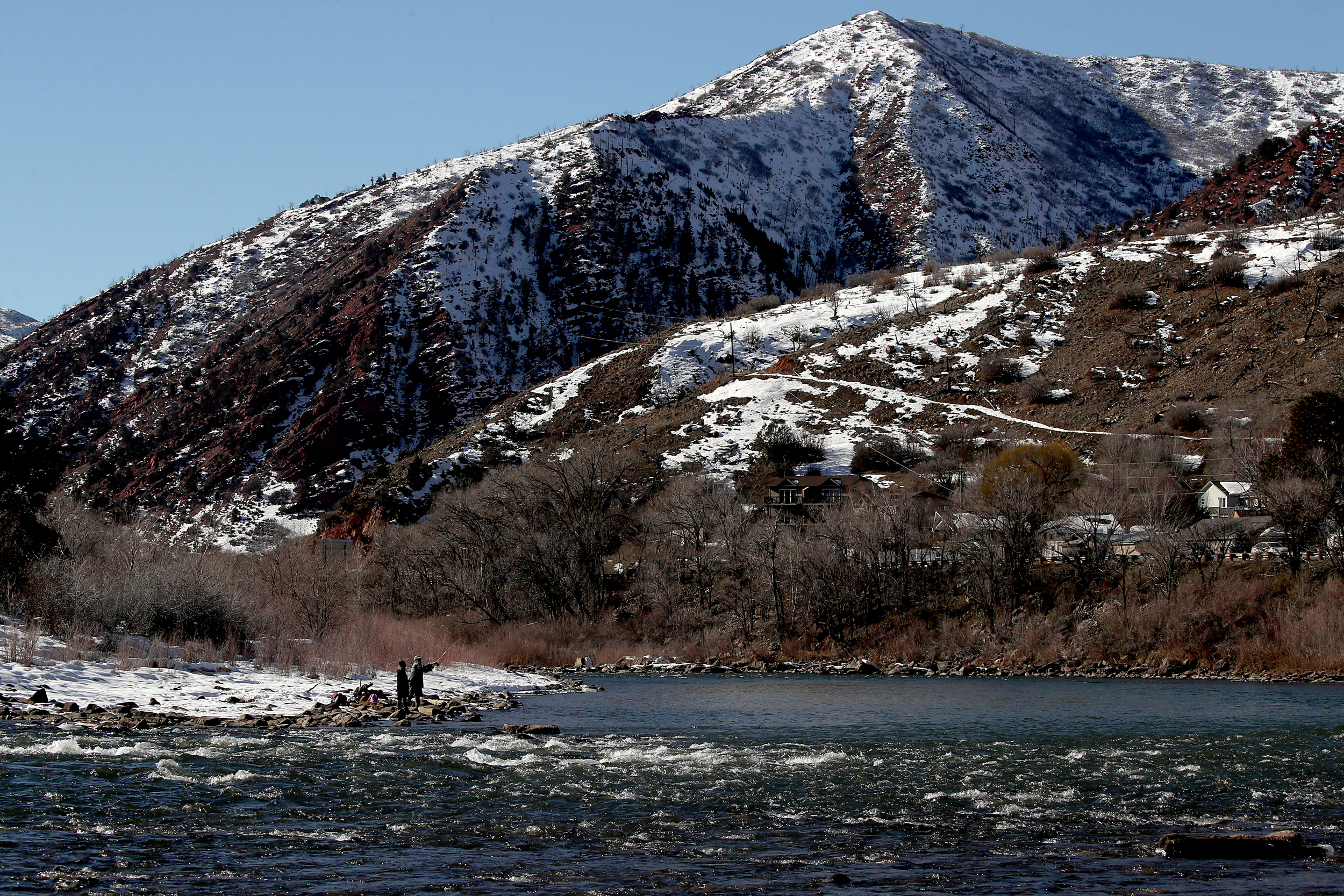 People cast their fishing lines into the Colorado River in Glenwood Springs, Colorado. Credit: Luis Sinco/Los Angeles Times via Getty Images