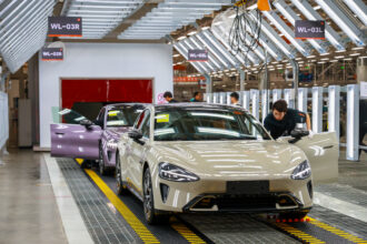 Employees work on the production line at Xiaomi's electric vehicle plant on March 25 in Beijing, China. Last year, 37 percent of new cars sold in China were electric and that figure could climb to 45 percent this year. Credit: VCG via Getty Images