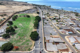 In an aerial view, lots that have been cleared of wildfire debris, covered in gray gravel, are seen as vehicles pass along a newly reopened stretch of Honoapi'ilani Highway on August 3 in Lahaina, Hawaii. Credit: Mario Tama/Getty Images