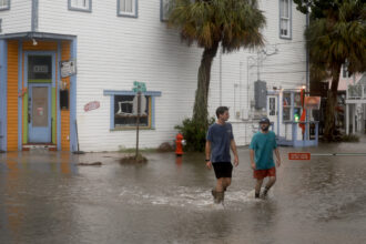 People walk through a flooded street caused by the rain and storm surge from Hurricane Debby on August 5 in Cedar Key, Florida. Credit: Joe Raedle/Getty Images