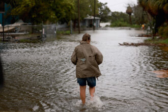 A person walks through a flooded street caused by the rain and storm surge from Tropical Storm Debby on Monday in Cedar Key, Florida. Credit: Joe Raedle/Getty Images