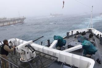 On Feb. 24, 2018, the Argentine Coast Guard discovered the Jing Yuan 626 fishing illegally within Argentina’s EEZ. Here, an Argentine Coast Guard member watches as Jing Yuan 626 and several other foreign fishing vessels crowd around during a pursuit. Credit: Javier Giannattasio