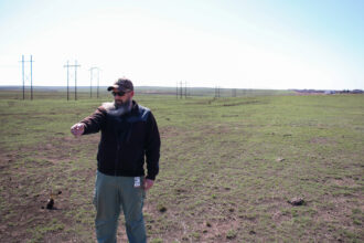 Archie Stone, the wildland coordinator for the Borger Fire Department, points to where the Windy Deuce fire stopped next to a 2023 prescribed burn line outside the city. Credit: Keaton Peters/Inside Climate News