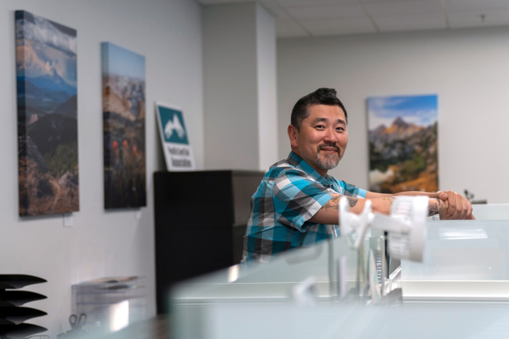 PCTA’s director of communications, Chris Rylee, is surrounded by nature-themed decor at the PCTA headquarters in  Sacramento, California. Credit: Bing Lin/Inside Climate News 