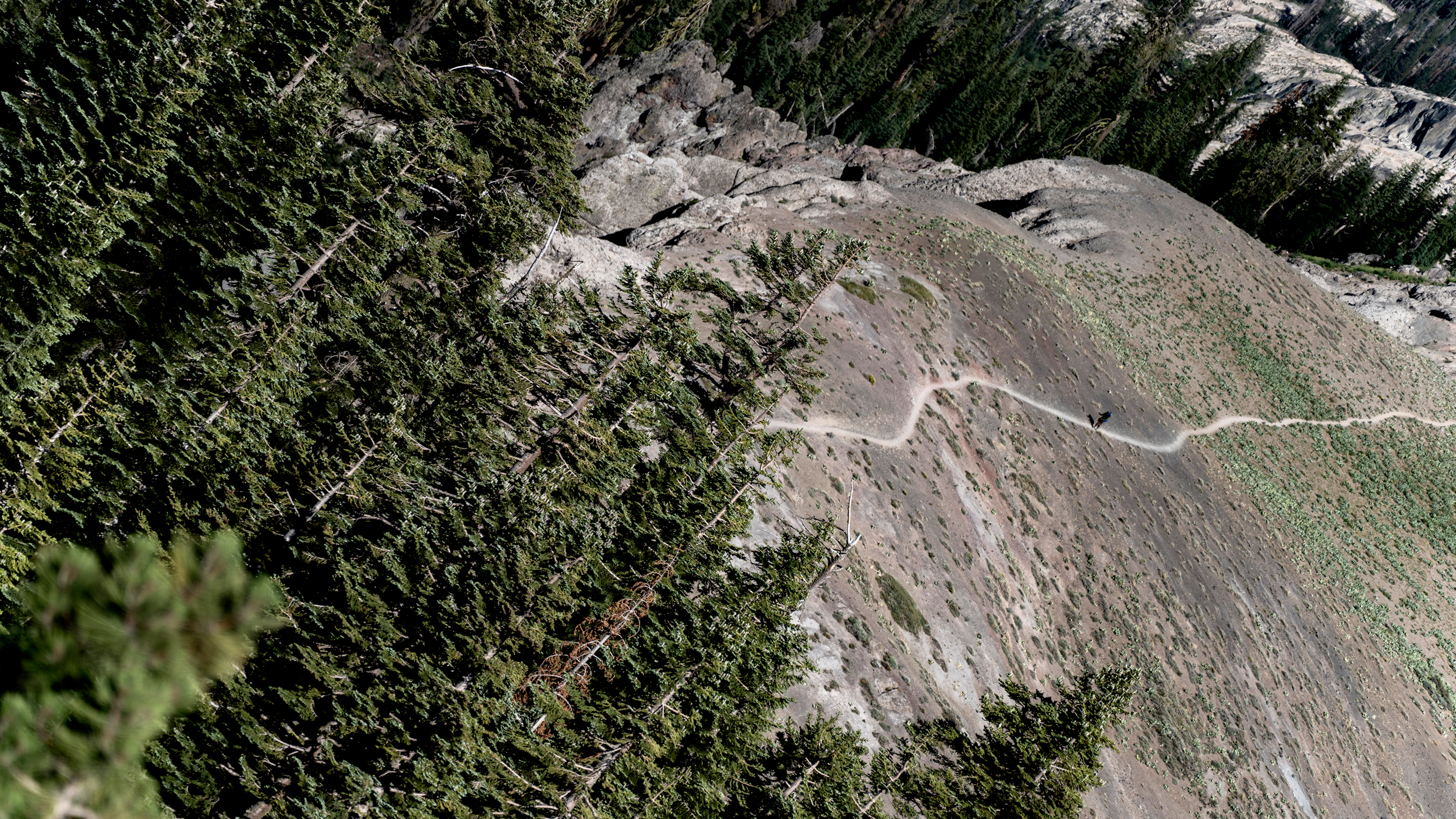 The Pacific Crest Trail footpath snakes along a mountain ridge south of Donner Summit, California, as a hiker climbs up the trail. Credit: Bing Lin/Inside Climate News